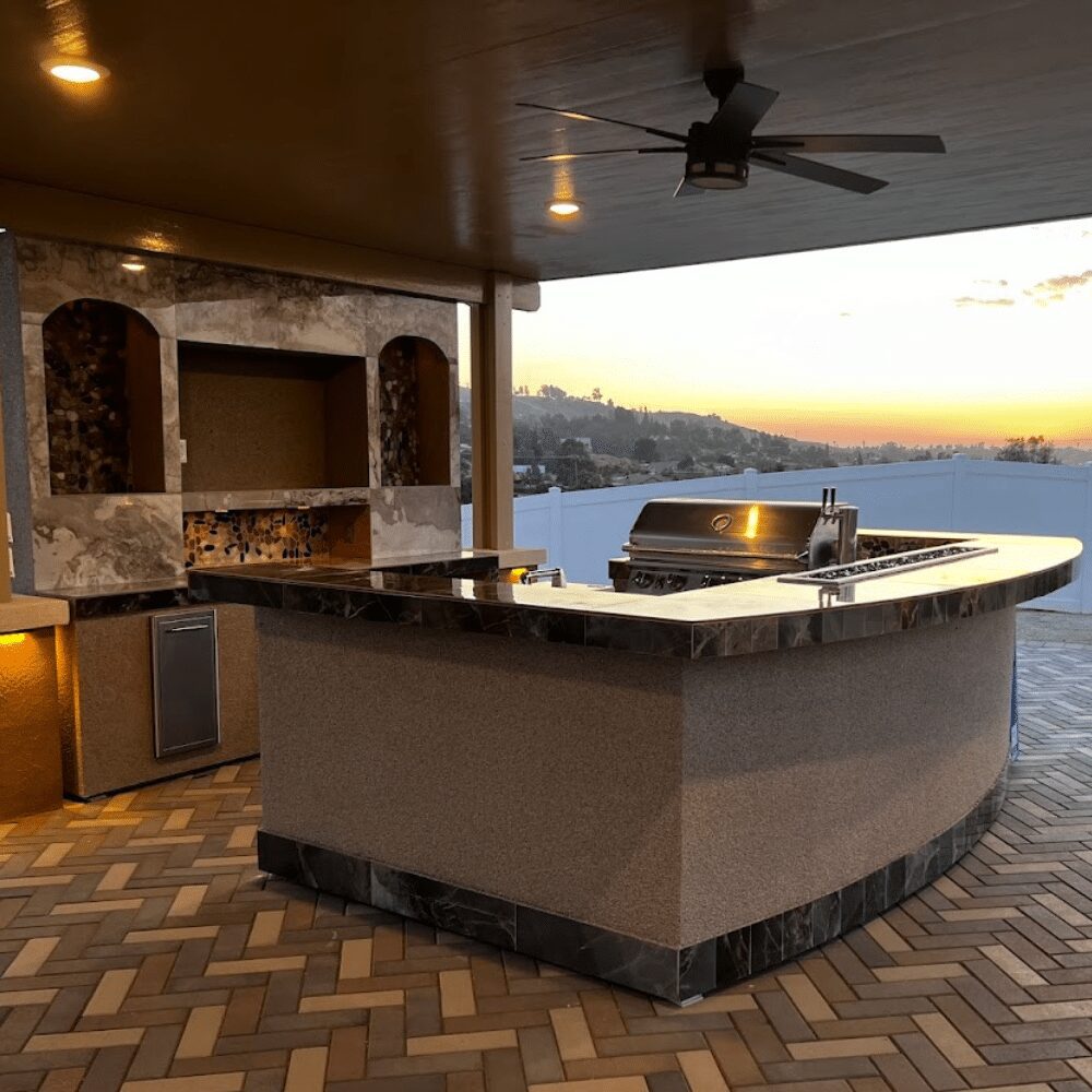 Custom Lion BBQ island outdoor kitchen with built-in grill, stone countertops and bar seating
