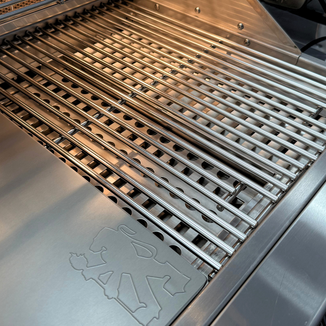 A massive tomahawk steak on gas grill grates roasting over glowing coals inside a premium Lion charcoal tray upgrade