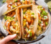 Rotisserie basket shrimp tacos on a Lion gas grill with cabbage slaw and lime served alongside the Napoleon rotisserie grill basket