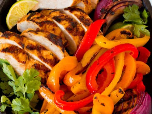 Chicken fajitas with peppers and onions cooking on the included Lion griddle