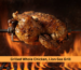Grilled whole chicken on a gas grill turning on a rotisserie spit over open flames