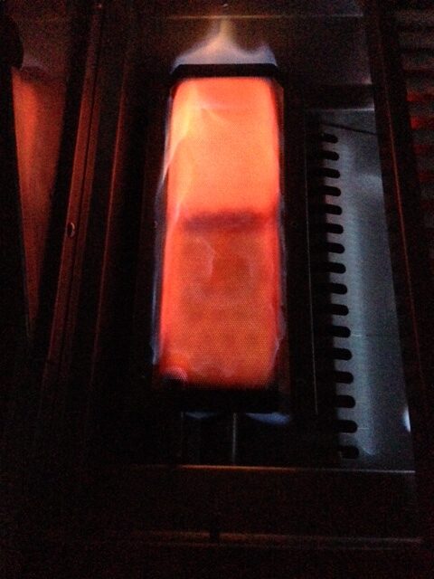 Lion infrared searing burner glowing red orange with intense heat for seared scallops on a grill
