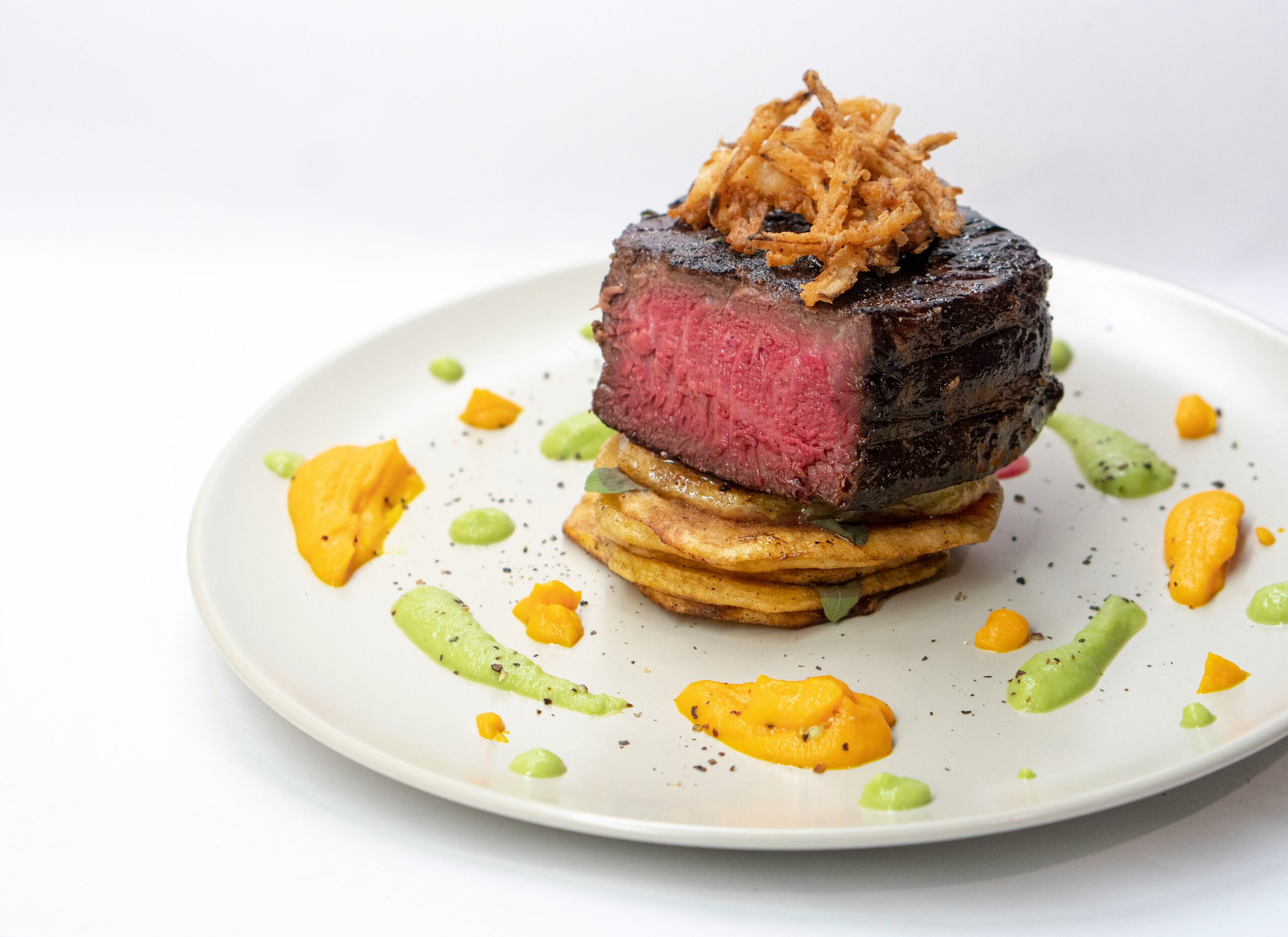 Finished grilled filet mignon with garlic herb butter on a plate steakhouse recipe from a Lion gas grill
