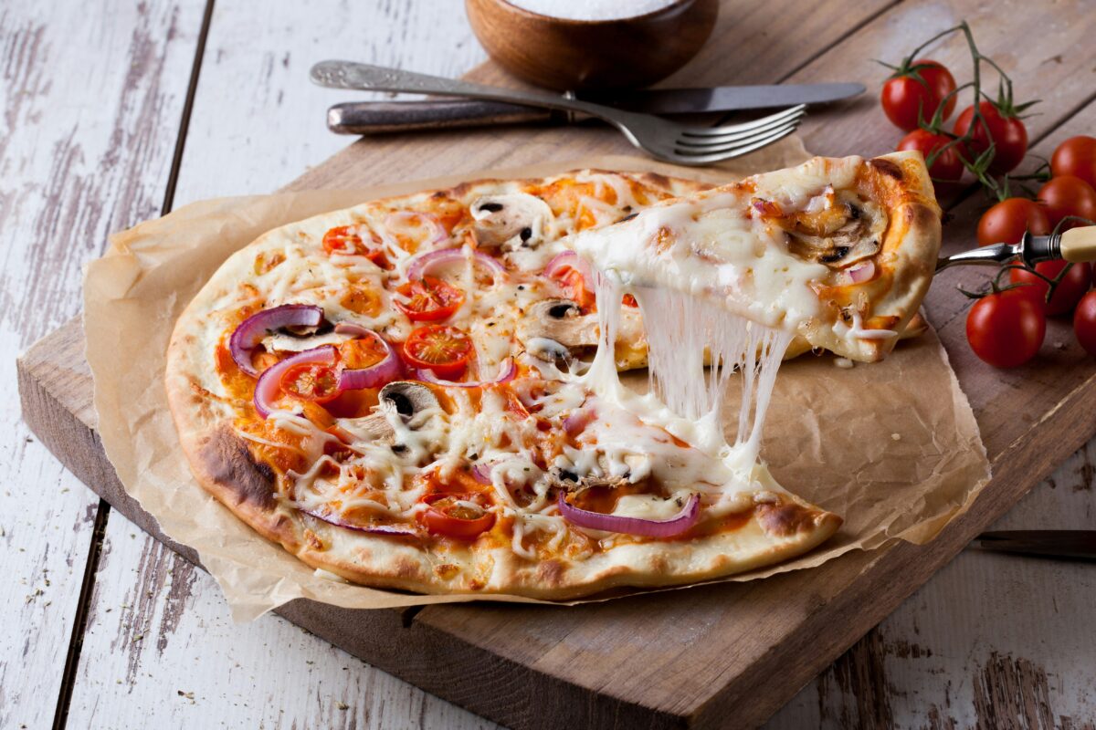 Grilled pizza with melted cheese cooking directly on gas grill grates