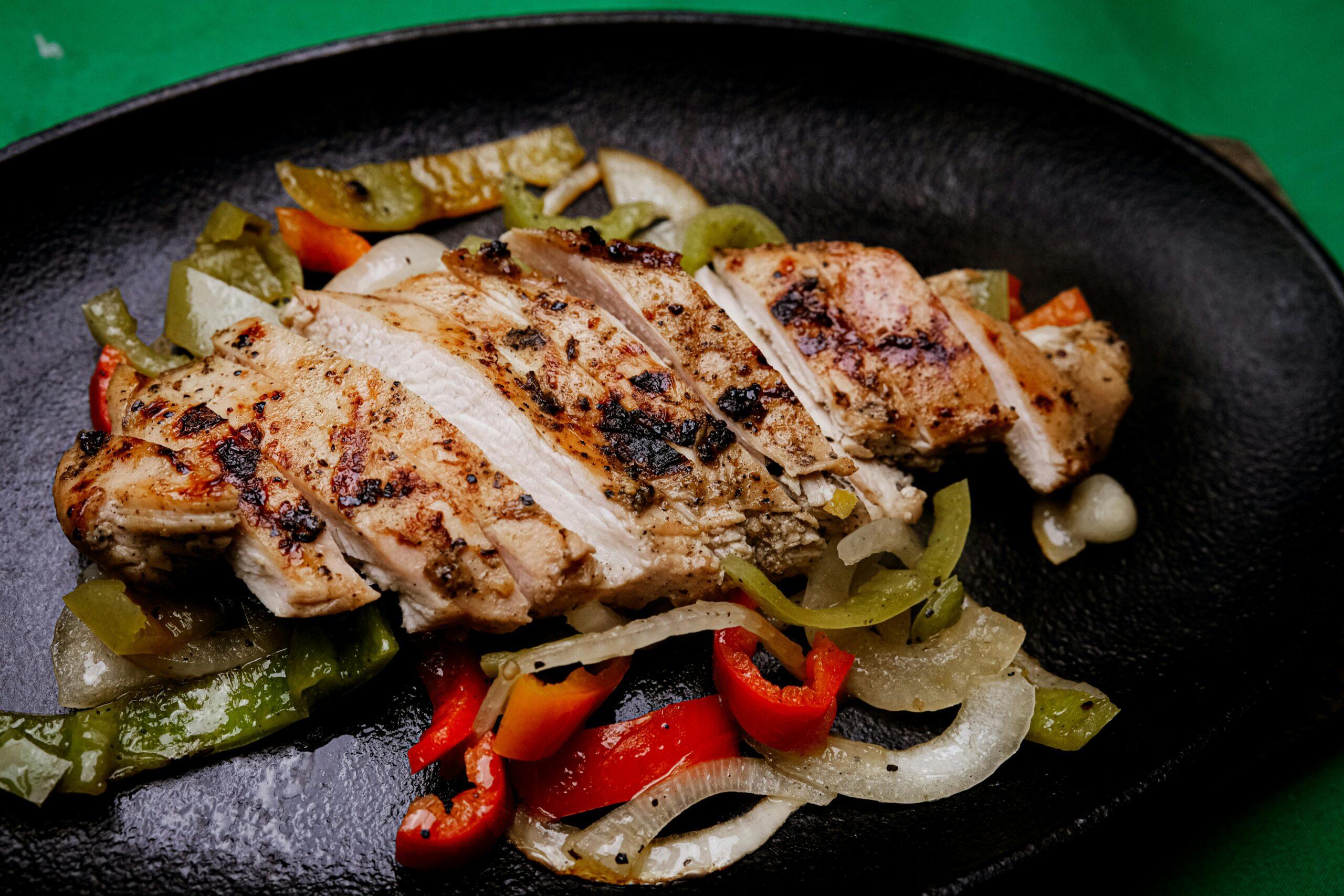Finished chicken fajitas with peppers and onions plated from the Lion grill griddle