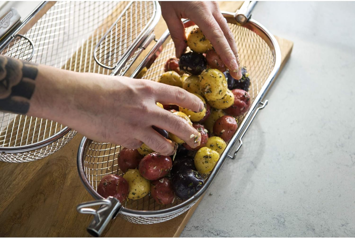 Seasoned potatoes placed inside Napoleon rotisserie grill basket ready for the Lion gas grill