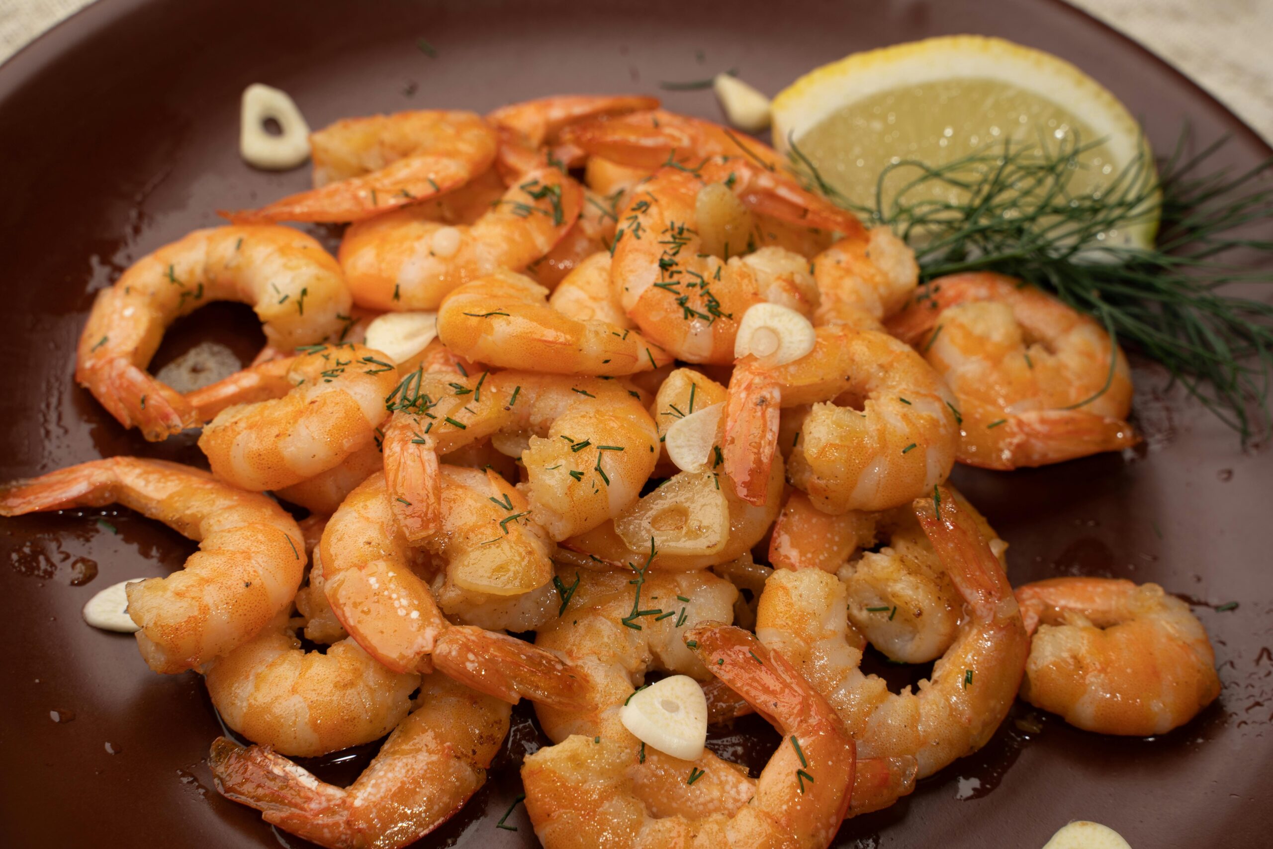 Cooked shrimp with garlic and lemon plated as a Cajun seafood BBQ recipe from a Lion gas grill