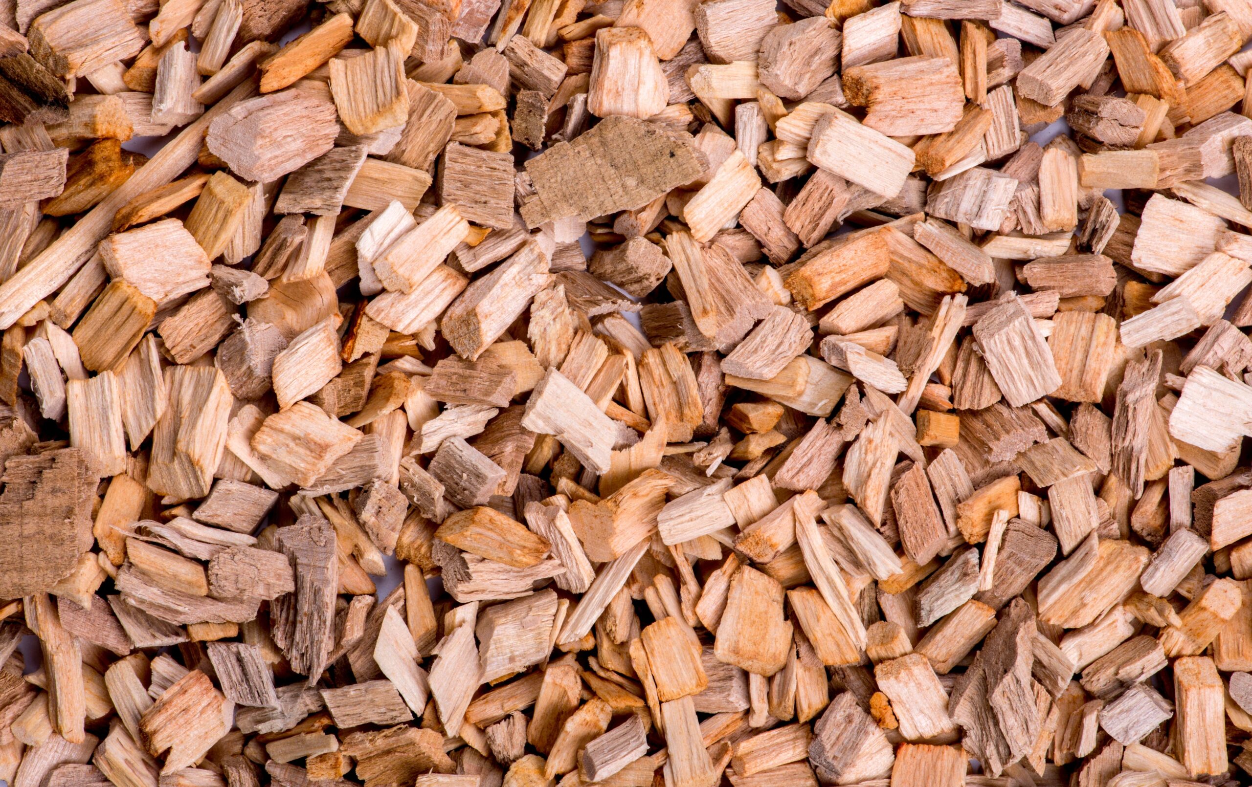 Close-up of premium raw wood chips selected for outdoor smoker box cooking profiles
